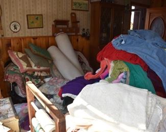 lots of quilts, pillows, farmhouse Americana, and a really cool shaker/farmhouse spindle bench under all the pillows!