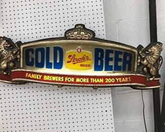 Story’s electrified Gold Beer sign with regal flanking lions.