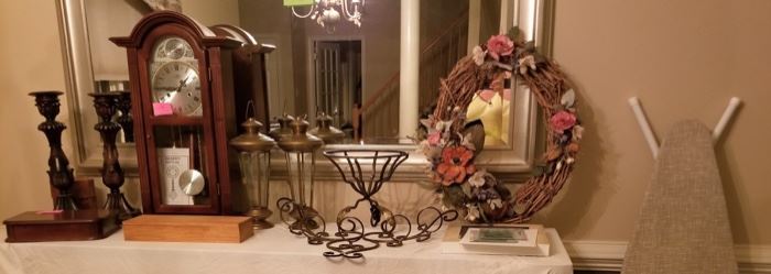 Large Candle Sticks, 2 Brass Lanterns, new ironing board, wreaths, many cigar boxes, wall sconce candle holder, beautiful cherry clock and more.