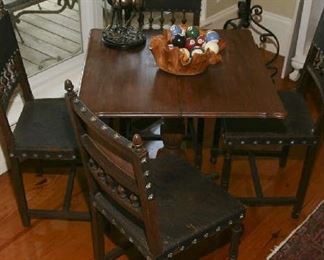 Game table with matching leather and oak antique chairs