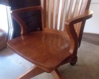 $75 - Wooden swivel desk chair on rollers. Can tilt back and change height.