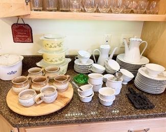 56- White Rosenthal china, white ceramic serving dishes, vintage pyrex porcelain bakeware, handmade pottery coffee mugs, wood lazy susan, green depression glass hand juicer, cast iron trivet