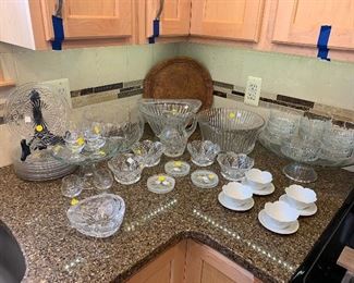 49- Gorgeous clear cut glass and crystal... large crystal bowls, large and small glass cake stand, cut crystal dessert bowls, coasters, set of clear depression glass plates, white ceramic flower dessert cups with saucers and vintage stamped leather round tray