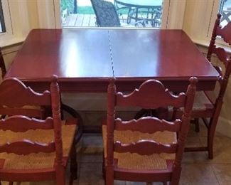 154- Super cute vintage painted wood kitchen table with wicker ladder back chairs, table extends with a hidden leaf , measures 45"w x 32"l x 30"h