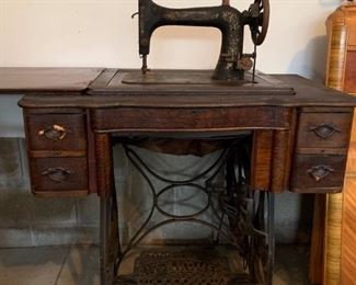 Antique sewing machine in oak cabinet.
