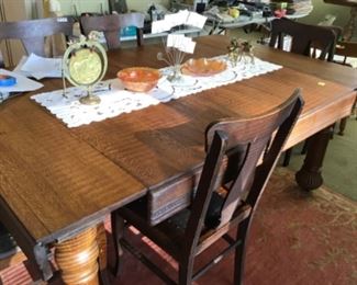 . . . this is one of two early 1900's dining tables.  This one is cool because the leaves are self-storing.  Set of 6 matching T-back chairs are hard to find.  
