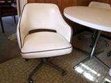 Retro dinette set. Round white laminate table, aluminum pedestal base, 4 matching white vinyl with black piping swivel tub chairs on wheels (one chair needs repair to base and one has a split in the vinyl).