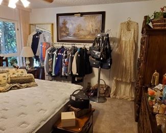 Master bedroom is filled with furniture, very nice ladies clothing, accessories and vanity items.