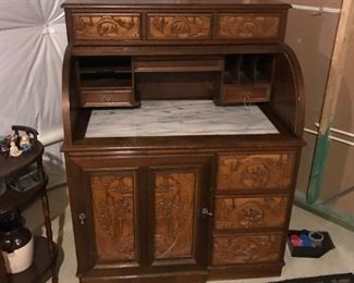Very unique carved wood rolltop desk.  Marble top, seat slides into desk and has more storage.  