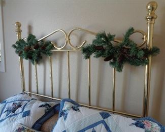 queen bed w/Christmas garland still attached