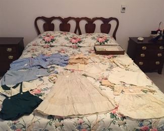 Queen bed with vintage baby clothes