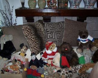 A FEW OF THE STUFFED ANIMALS ON THE SECTIONAL SOFA