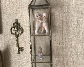 Glass curio wall cabinet with kewpie dolls