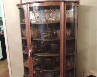 bow front Victorian Cabinet with a mirrored top with a lot of Pink Adam Depression glass