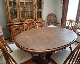 Beautiful oak dining room table and matching hutch, plus table cover, six chairs and leaf