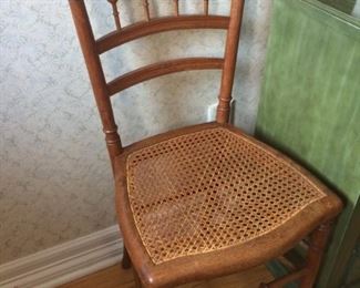 One of two antique cane seat chairs