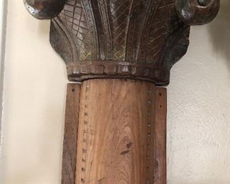 Tall, carved wooden pillars with stone base.