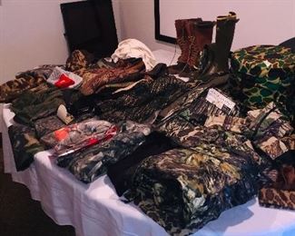 Stacks of new hunting clothes -most with tags
