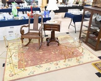 Several antique rocking chairs, book cases/shelves, lamps, and large area rugs.