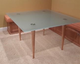 Frosted glass table with blonde wood legs. So nice!