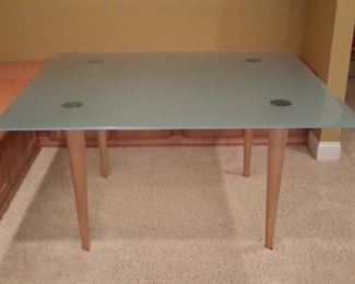 Frosted glass table with blonde wood legs. So nice!