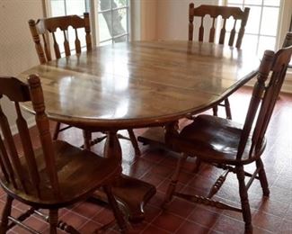 Sturdy double pedestal kitchen table with four chairs and one leaf.