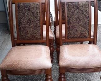 Eight dining room chairs (two not pictured) with distressed leather seats.