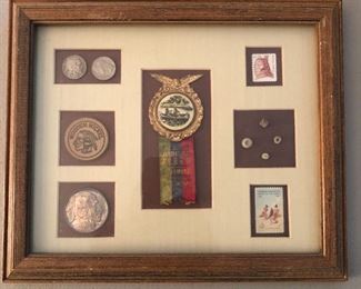Framed assortment of Native American-themed items, including 1911 Annual Jubilee pinback/ribbon, coins, stamps, etc.