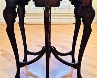 A CARVED WOOD CENTER TABLE WITH SIX CURVED LEGS: Diameter 20 inches x Height 34 inches. 