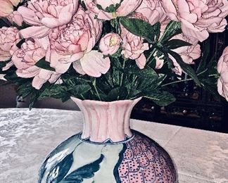 A blue and pink vase with silk flowers.