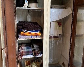 Interior of knock down wardrobe. Sheets, some vintage, hats, afghans, blankets