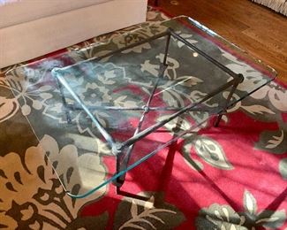Glass top coffee table with forged metal base