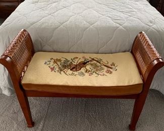 Stool with needlepoint top and wicker sides.