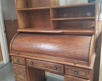 Roll top desk with custom built top book case.