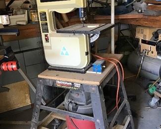 Delta bandsaw, mounted on table with vacuum for dust collection.