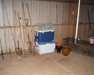 fishing poles, ice chests, rake, shovels, pitchforks, large animal cage
