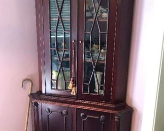 Dapper china corner cabinet keeps cane at the ready