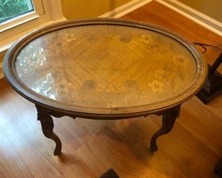 nice round coffee table with inlayed wood and an aura of accomplishment