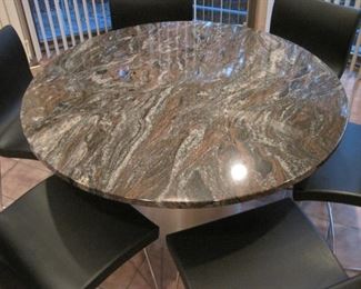 A set of six Ligne Roset Sala Chairs with a marble topped pedestal table.