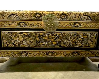 Intricately carved wooden trunk from China.   Trunk has carved dragons with floral pattern  throughout. Brass metal hardware with etched  design. Sits atop simplified paw feet.  Measures approx 14.25 inches in height by 27 inches in width by 14 inches in depth. Good  condition, minor scuff of wood in back.  Chinese chest, trunk, storage organization,  carved wood chest, dragon details, Chinese  East Asian home decor accessory, decorative accessory. 7
