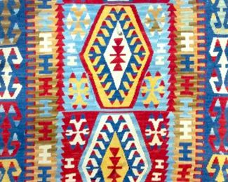 Rug is handmade and wool. Rug up is vintage.  Piece contains multi toned geometric detail  with tones of red, beige, blue, cream, light  blue. Piece has tied fringes. Piece measures  approx 68 inches long 46 inches wide. Contains some wear and small holes.  rug,  carpet arts and crafts, decorative arts and  design, home decor, interior design,  geometric design 