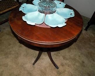 Nice round pedestal table.  On top is Hoenig of California Pottery ceramic serving set No. 734 and was manufactured in the USA. It was designed to be used with a lazy-susan which is not available. When arranged together the set measures approximately 17" in diameter. The original center covered dish is missing.  Each apple dish measures 6" long and almost 6" at its widest point. Good condition
