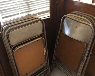 Numerous folding metal chairs