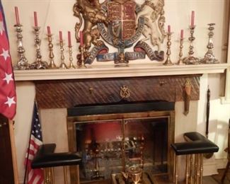 CAST IRON FAMILY CREST WITH PROVENANCE OVER FIREPLACE WITH FENDER SEAT AND FOOTMAN