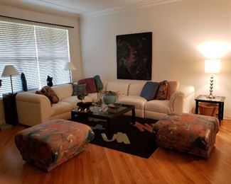 What a Grouping! White Sectional Couch, Two Large Ottomans, Fabulous Carpet and Wall Art, Glass Coffee Table and Matching Side Table, Assorted Professionally picked Table decorations, Sofa Table, Large Basket, Three Lamps, and Gorgeous Throw Pillows that just brings it all together!!  Love it? Want it all?
