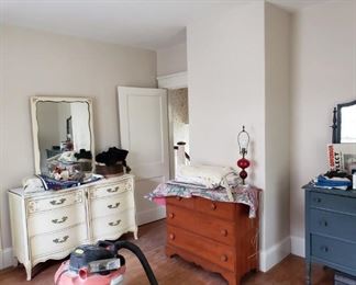 Bedroom furniture.  White dresser has a matching bureau with built in bookshelf.  Brown bureau has a matching dresser.