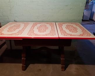 Rare antique porcelain table top with pull out leave. Art deco design.  The base of the table is wood and has a drawer. Table is in excellent working condition with the leaf pullout easily. 