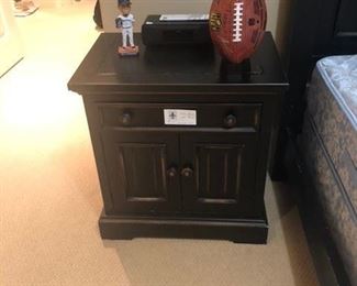 Bedside table shown with Felix bobble head and signed Seahawks signed football