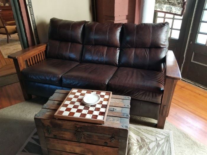 Genuine Leather Sofa with Craftsman style detailing in oak.  Very gently used to watch others playing pool in the Sun Room.  This is not antique but is a convincing reproduction of a Craftsman piece - and less age.  (The trunk is not being sold.)