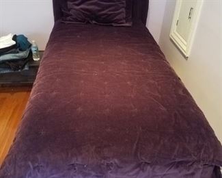 Pair of twin beds with purple velvet headboards and bedding all matching